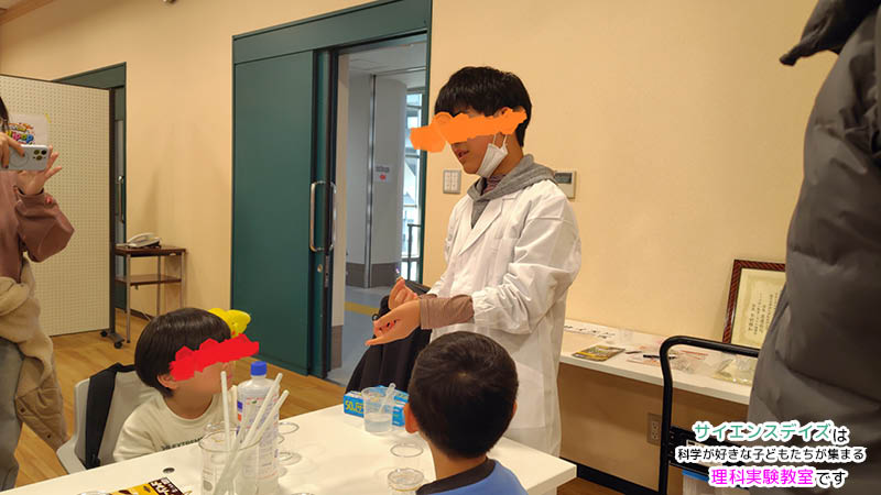 来場者に向けてスライムが光る仕組みを丁寧に説明する小学生の男の子 - 自分の言葉で伝える力を育むサイエンスデイズのアウトプット型教育