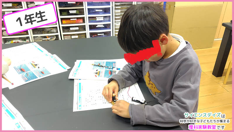 乾電池と豆電球をつないで回路を作る低学年の子ども - 配線の基本を学ぶサイエンスデイズの理科実験教室