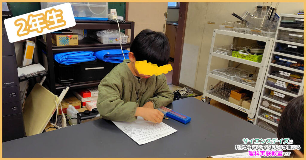 アルコールランプの説明書を書いている子どもの手元 - サイエンスデイズの低学年クラス