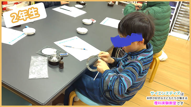 三脚を組み立てる低学年の子ども - サイエンスデイズの授業風景