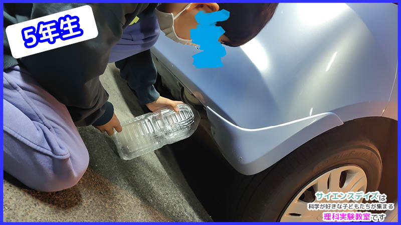 車の排気ガスをペットボトルに集めて二酸化炭素を調べる高学年児童 - 環境問題を実験から考えるサイエンスデイズの理科教室
