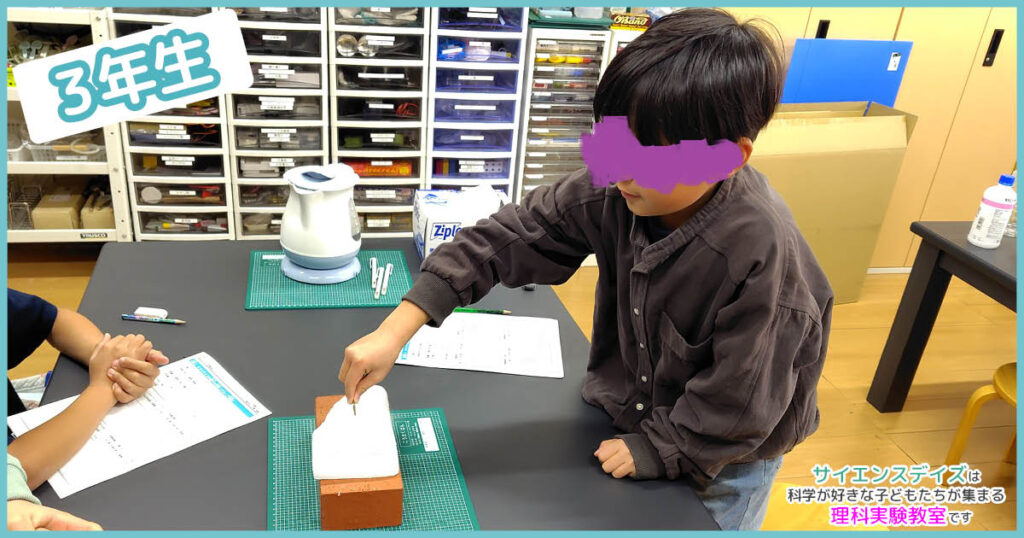 ドライアイスに10円玉を差し込む男の子 - サイエンスデイズの授業風景