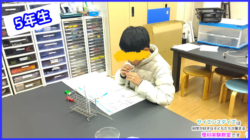 石灰水に息を吹き込んで二酸化炭素の存在を確かめる高学年児童 - 目に見えない気体を発見する体験学習のサイエンスデイズ