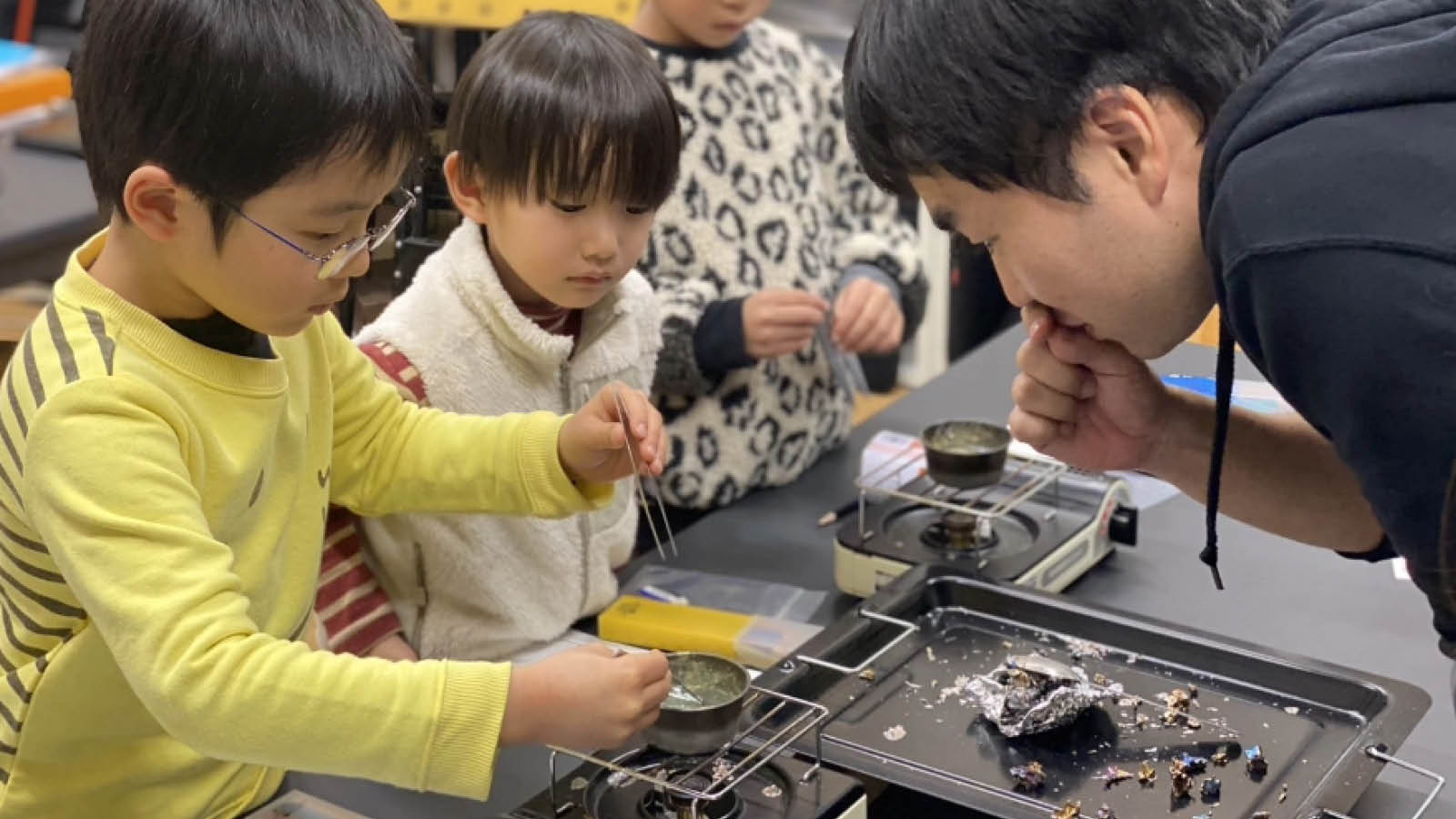 実験器具を使って真剣に科学実験に取り組む小学生とスタッフ - サイエンスデイズの出張理科実験ワークショップ