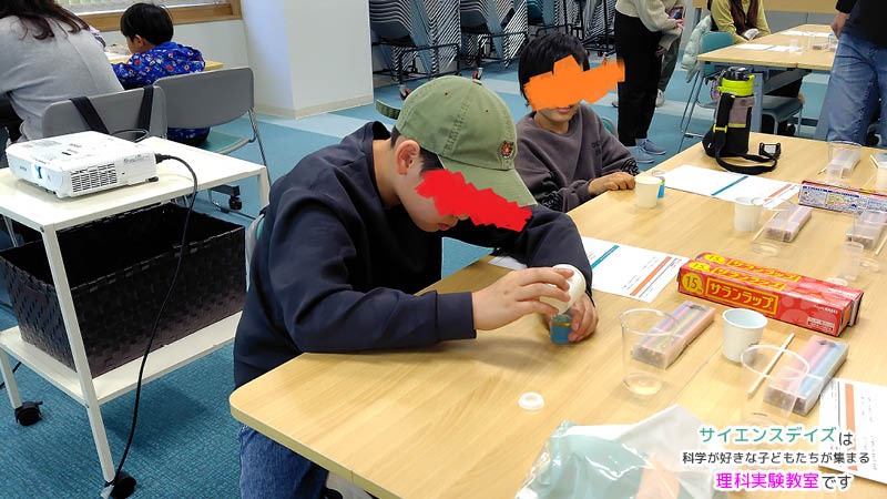 水と油の実験の準備をする男の子 - サイエンスデイズの出張理科実験ワークショップ