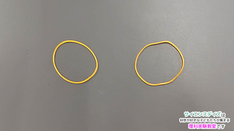 ビー玉ごまに使う輪ゴム2本を机に並べた写真